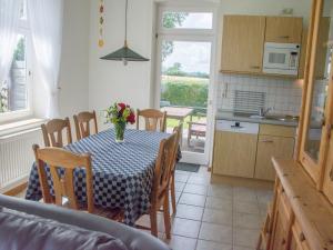 a kitchen with a table with a vase of flowers on it at Landurlaub Regenholz in Kronsgaard