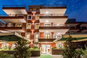 an apartment building with a green lawn in front of it at Hotel Cvita in Split