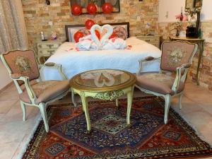 a bedroom with a bed with a table and two chairs at farmer’s suite room in Bat Shelomo