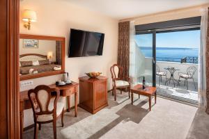 a room with a bed and a desk with a mirror at Hotel Cvita in Split
