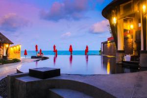 a group of people in red robes standing in front of the ocean at Kirikayan Boutique Resort - SHA Extra Plus in Chaweng