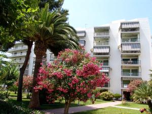 un edificio de apartamentos con flores rosas delante de él en Zeus Auriga, en Salou