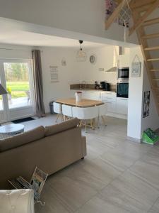 uma cozinha e sala de estar com um sofá e uma mesa em Gîtes des champs & Spa em Bavent