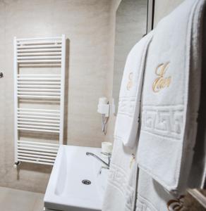 La salle de bains est pourvue d'un lavabo et d'une serviette blanche. dans l'établissement Pensiune EDEN, à Slatina