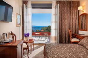 a hotel room with a bed and a desk and a room at Hotel Cvita in Split