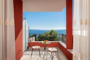 a balcony with a table and chairs and the ocean at Hotel Cvita in Split