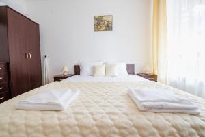 a bedroom with a large bed with two towels on it at ASPEN GOLF RESORT Ski & Spa RELAX APARTMENT in Bansko