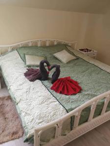 two black swans are laying on a bed at Apartamentai Rimkuose in Klaipėda