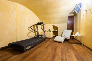 - une salle de sport avec un tapis de course et une chaise dans l'établissement ROMAC Coronari with gym, sauna and garden, à Rome