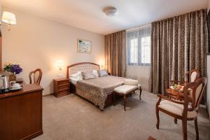 a bedroom with a bed and a table and a chair at Hotel Cvita in Split