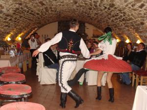 Quelques personnes dansant sur une piste de danse dans l'établissement Pivnica a Penzion pri studni, à Detva