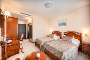 a hotel room with two beds and a table at Hotel Cvita in Split
