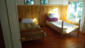 pokój z dwoma łóżkami piętrowymi i oknem w obiekcie Cabaa Hualle con hot tub exclusivo cerca de termas y lago w mieście Coñaripe