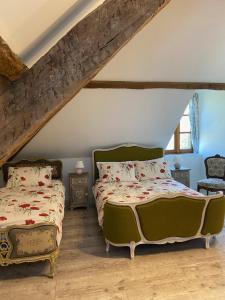 two beds in a bedroom with a attic at L'Enquenoiulle Basse in Verdun-en-Lauragais