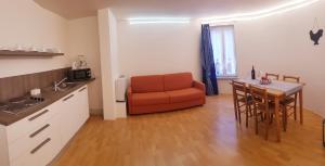 a kitchen with a table and a red couch in a room at Appartamenti Vacanza Il Riale in Cannobio