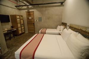 um quarto de hotel com duas camas e uma secretária em The Bricks Hotel em Dumaguete