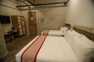 a hotel room with two beds and a desk at The Bricks Hotel in Dumaguete