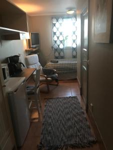 ein kleines Zimmer mit einem Tisch und einer Küche mit einem Fenster in der Unterkunft Broby Bed & Breakfast entréplan in Nyköping