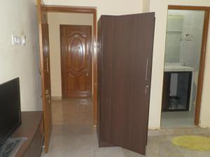 a wooden door in a room with a bathroom at Aldrin Guest House in Palolem