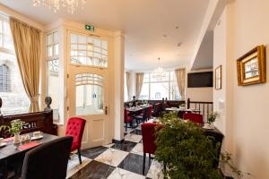 a restaurant with tables and chairs in a room at Haus Maximilian in Erfurt