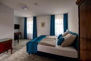 Schlafzimmer mit einem großen Bett und blauen Vorhängen in der Unterkunft Haus Maximilian in Erfurt