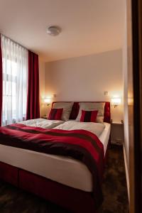 a bedroom with a large bed with red curtains at Haus Maximilian in Erfurt