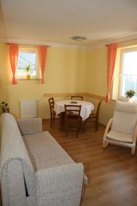 a living room with a couch and a table and chairs at Apartmány Záhořovo Lože in Horní Planá