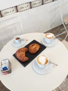 a white table with two cups of coffee and a pastry at B&B Acquamarina in Lido di Ostia