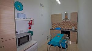 a kitchen with a table and a clock on the wall at Apartment close to Fort Saint Angelo in Vittoriosa