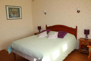 a bedroom with a bed with two pillows on it at Chambre au bruand in Saint-Porchaire