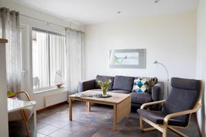 ein Wohnzimmer mit einem Sofa, einem Tisch und Stühlen in der Unterkunft Åhus Resort in Åhus