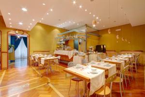 ローマにあるホテル コロトのテーブルと椅子が備わるレストラン