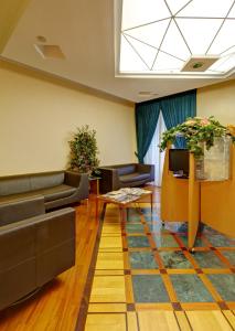 a lobby with couches and a table and a skylight at Hotel Corot in Rome