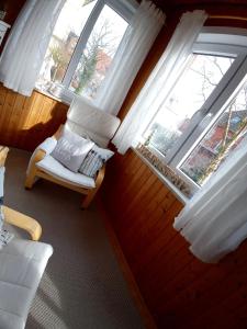 a room with a chair and two windows at Haus Strandburg Amrum in Wittdün