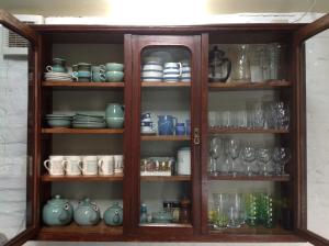 une armoire remplie de beaucoup de vaisselle et de verres dans l'établissement Potato, Barafundle Barns, SA71 5LS, à Pembroke
