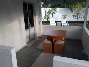 a porch with a wooden table and chairs on a house at Mi Casa Bentota in Bentota