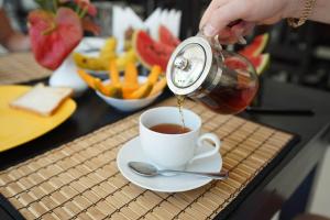 a person pouring coffee into a cup on a table at Mi Casa Bentota in Bentota