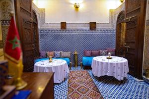Habitación con 2 mesas y sillas en una habitación en Dar Settash en Fez