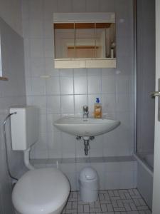 Ferienhaus Jungclaus في Hechthausen: حمام مع حوض أبيض ومرحاض