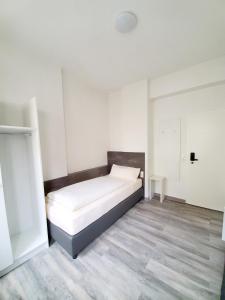 a white bedroom with a bed in a room at Zimmervermietung Sanderstrasse in Würzburg