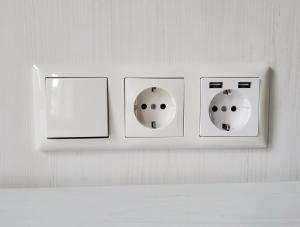 a white lightswitch with three switches on a wall at Zimmervermietung Sanderstrasse in Würzburg