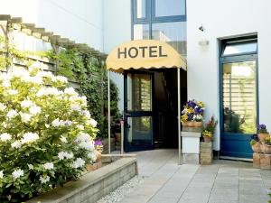 a hotel entrance with a blue door and flowers at Cabo Nonsmoking-Hotel  in Hamburg