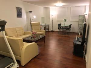 斯塔萬格的住宿－欣娜天堂公寓，客厅配有沙发、椅子和桌子