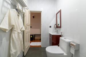 a white bathroom with a toilet and a sink at Gunbaru Inn in Ukulhas