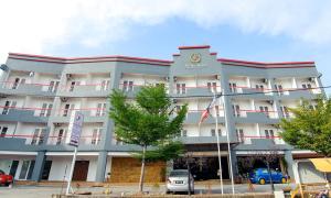 un gran edificio con coches estacionados frente a él en Prima Hotel Melaka en Melaka