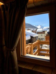 una ventana con vistas a una montaña nevada en Le Chalet Luxury Apartment, en Livigno