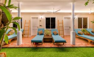 a living room with blue chairs and a table at Gunbaru Inn in Ukulhas