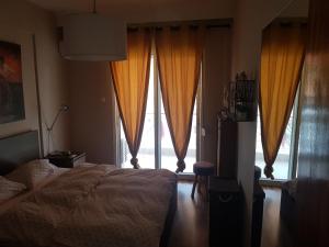 een slaapkamer met een bed en een groot raam bij Top Floor Apartment in Komotini