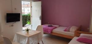- une chambre avec un lit, une table et une télévision dans l'établissement Accommodation Vesa, à Mostar