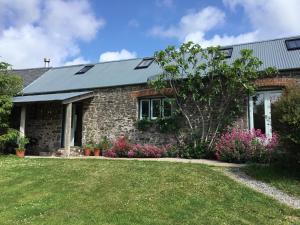 a stone house with a garden in front of it at Potato, Barafundle Barns, SA71 5LS in Pembroke